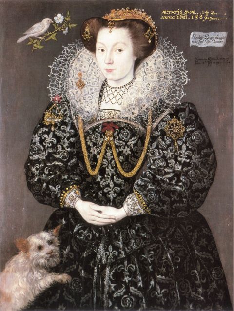 An elaborately dressed Elizabethan girls posed with a small dog.